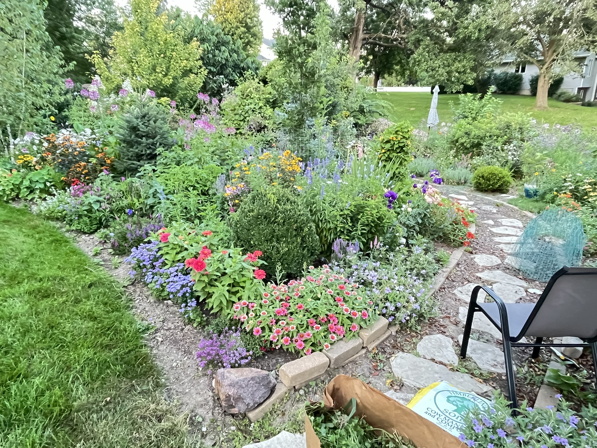 Lush garden bed with mixed perennials and stone path